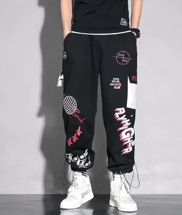 Men's harem pants with graphic design, black with white and red accents, paired with white sneakers.