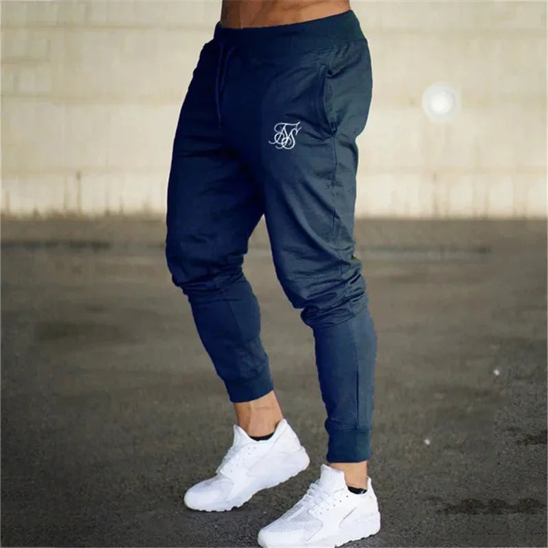 Men's fitness pants in sleek pencil design, mid-waist fit, dark shade, lightweight material.